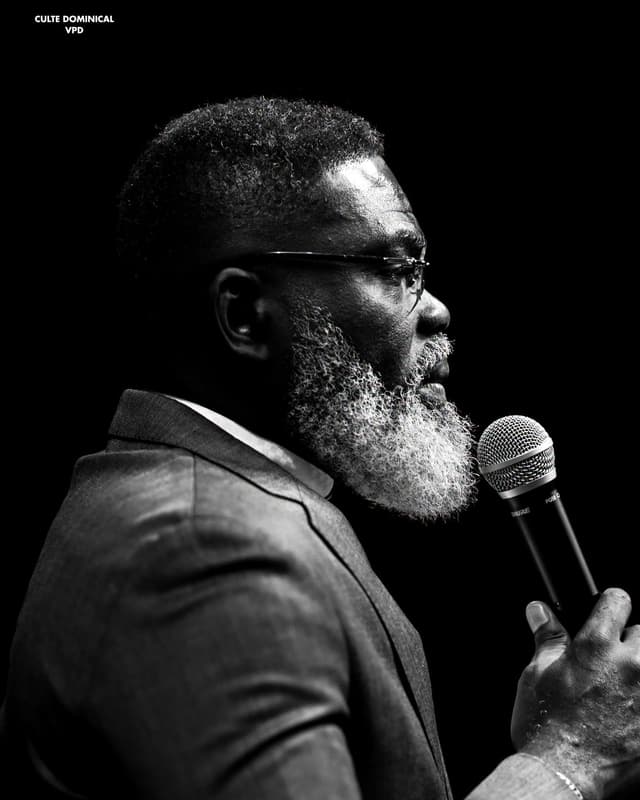 Révérend Francis Ngawala au micro devant l'assemblée